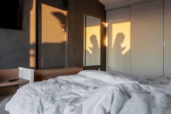 Ηλιόλουστη κρεβατοκάμαρα σε μοντέρνο στυλ με γκρίζο τοίχο — Φωτογραφία Αρχείου