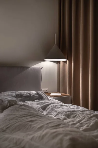 Стильная спальня в современном стиле с светящейся лампой — стоковое фото
