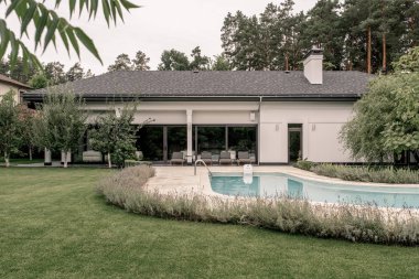 Yüzme havuzu ve geniş çim ile şık villa