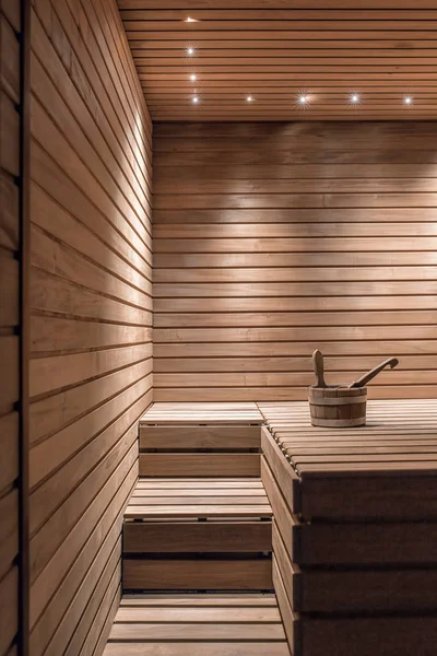 带水桶和勺子的照明木制桑拿浴室 — 图库照片