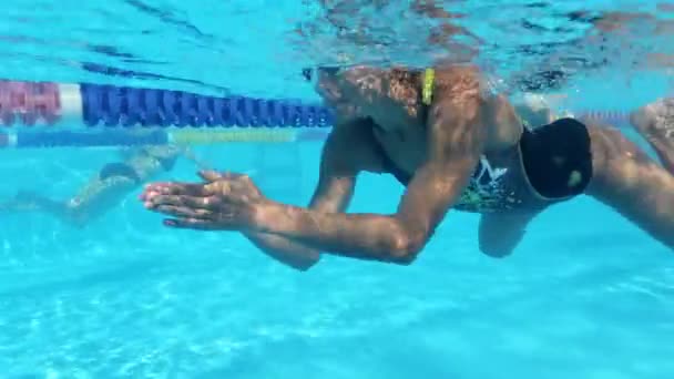 Mujer está nadando bajo el agua en la piscina durante el entrenamiento de triatlón — Vídeos de Stock