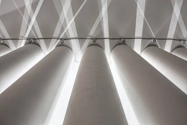 Белые текстурированные колонны на фоне бетонного потолка — стоковое фото