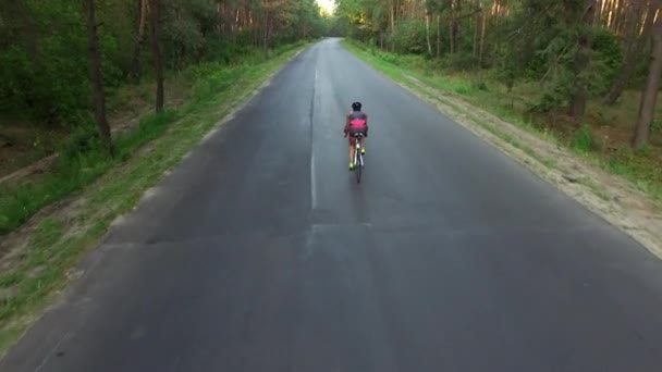 Mujer está en bicicleta en carretera durante el entrenamiento de triatlón — Vídeos de Stock