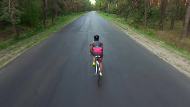 Mujer está en bicicleta en carretera durante el entrenamiento de triatlón — Vídeo de stock