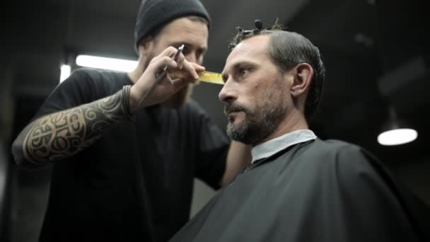 Haircut of dark haired bearded man in barbershop — Stock Video