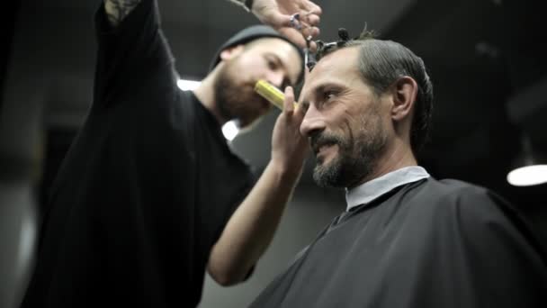 Corte de pelo de hombre barbudo de pelo oscuro en la peluquería — Vídeos de Stock