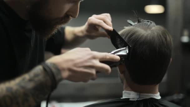 Corte de cabelo de cabelos escuros barbudo homem na barbearia — Vídeo de Stock