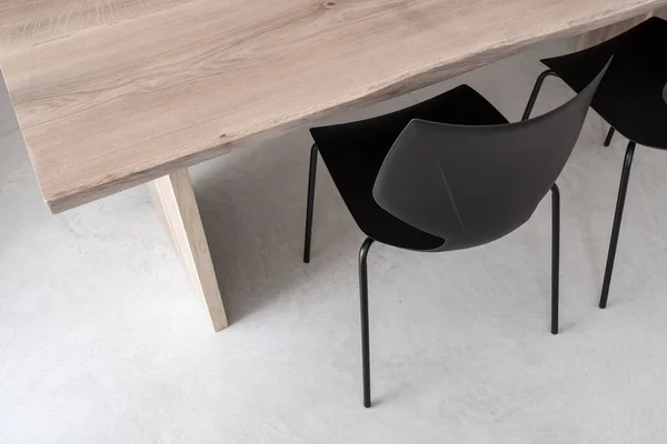 Dvě černé židle od světle dřevěný stůl — Stock fotografie