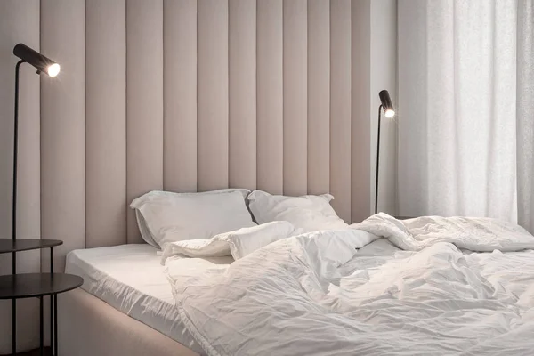 Стильная спальня в современном стиле с коричневой текстильной стеной — стоковое фото