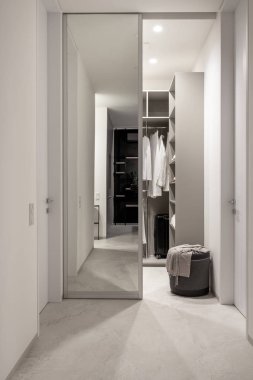 Modern wardrobe with sliding mirrored doors and luminous lamps clipart