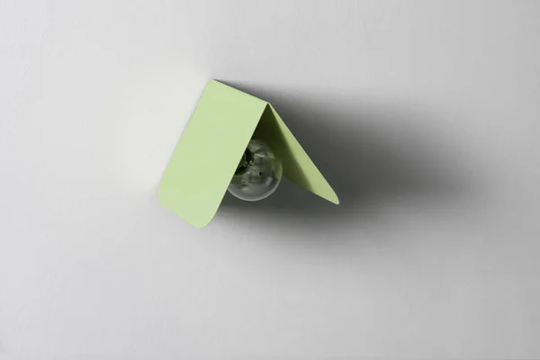 Fancy green metal lamp on gray wall in studio — Stock Photo, Image