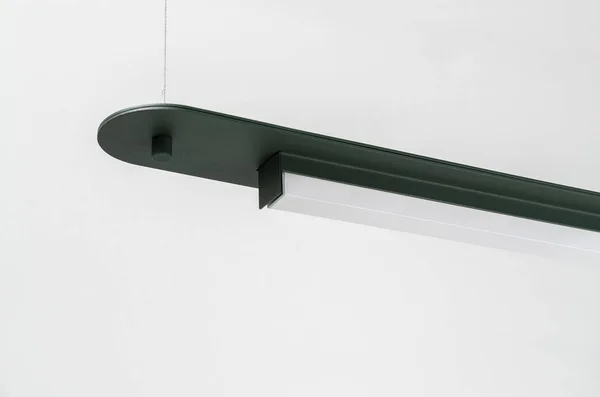 Lâmpada de metal verde escuro pendurado no fundo da parede cinza no estúdio — Fotografia de Stock