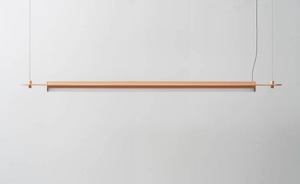 Оранжевая металлическая лямка висит на фоне стены в студии — стоковое фото