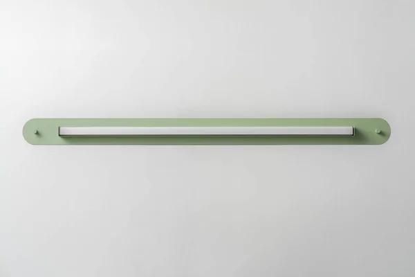 Lámpara de metal verde sobre fondo de pared gris en estudio — Foto de Stock