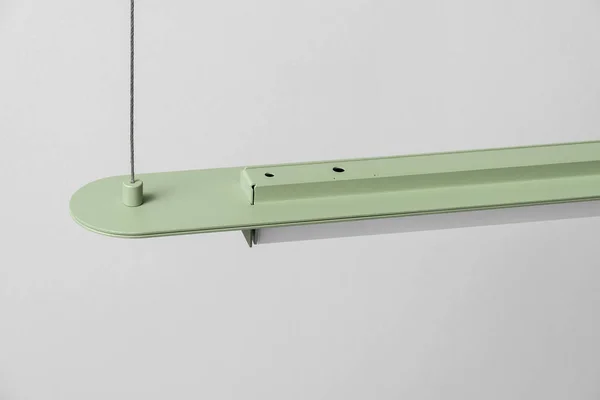 Candeeiro de metal verde pendurado no fundo da parede cinza no estúdio — Fotografia de Stock