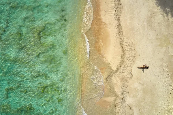 Top view at tropical sand beach with sunbathing girl — Stock Photo, Image