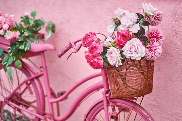 Bright pink bike with flowers in its baskets outdoors — Stock Photo, Image