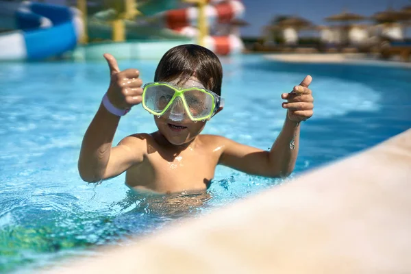 Küçük çocuk yeşil yüz maskesi aquapark alanına poz — Stok fotoğraf