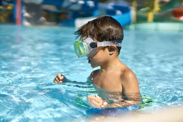 Malý chlapec pózuje v masce zelené plavání v aquaparku — Stock fotografie