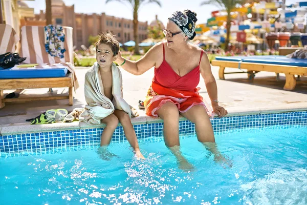 老太太和她的孙子在度假村的游泳池附近放松 — 图库照片