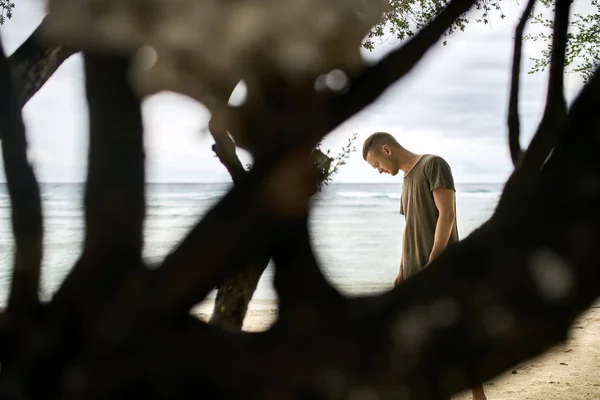 Красивый парень стоит на тропическом песчаном пляже — стоковое фото