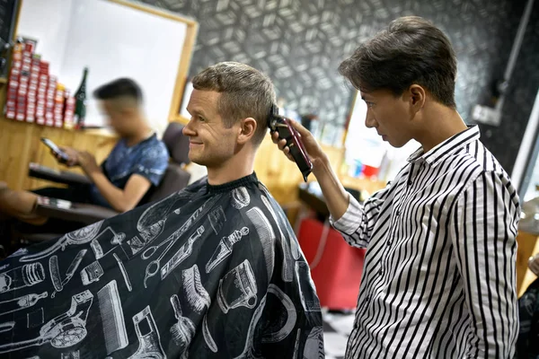 Man is cutting his hair in asian barbershop