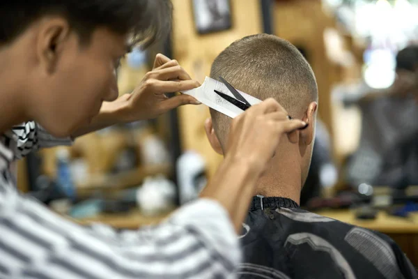 Man is cutting his hair in asian barbershop
