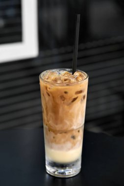 Renkli buzlu kahve içecek açık havada siyah masada koyu saman ile