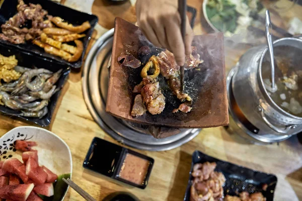 Visitante de restaurante tradicional vietnamita cocinar carne en olla caliente — Foto de Stock