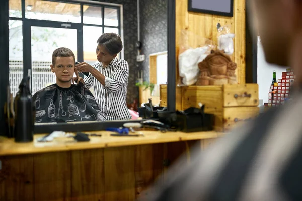 Hombre está cortando su cabello en asiático barbería — Foto de Stock