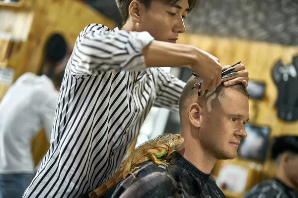 Hombre está cortando su cabello en asiático barbería — Foto de Stock