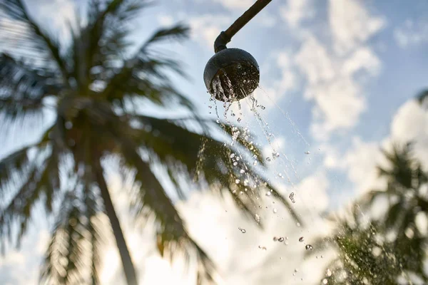 Doccia sulla spiaggia con acqua che scorre sul vecchio tubo di metallo — Foto Stock