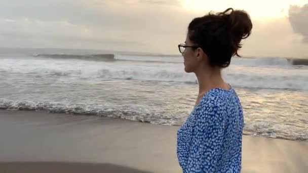 Garvade flicka promenader på stranden på vågiga havet bakgrund — Stockvideo