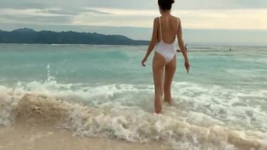 Tropik sahilde dalgalar deniz sıçramasına mayo memnun kadın