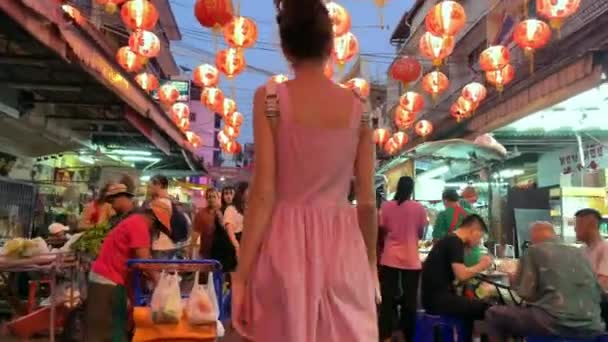 Vrouw lopen in de avond op verlichte straatmarkt in Thailand — Stockvideo