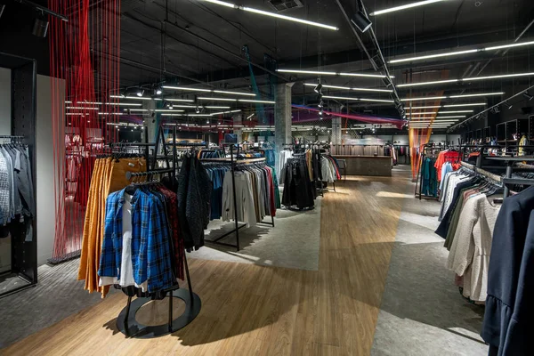 Modern clothes shop with large selection of different wear and shoes — Stock Photo, Image