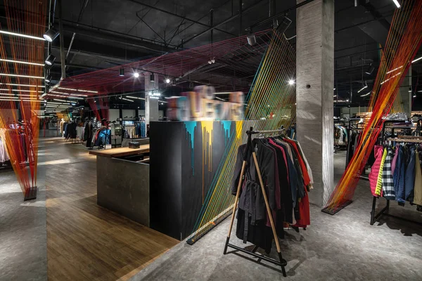 Modern clothes shop with large selection of different wear and shoes