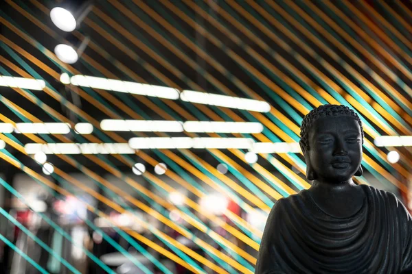 Busto de Buda em interior iluminado com instalação de linhas de cordas coloridas — Fotografia de Stock