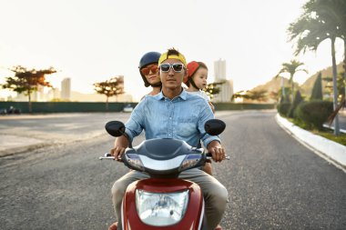 Güneşli şehir caddesinde motosiklet sürme küçük çocuk ile Ebeveynler