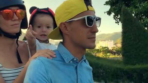 Genitori con il loro piccolo bambino in moto sulla strada soleggiata della città — Video Stock