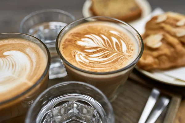 Milk coffee with croissant and bread and water on wooden table — Stock Photo, Image