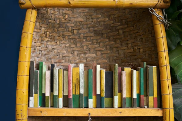 Πολύχρωμα σανίδες σε μορφή βιβλίων σε ράφι μπαμπού — Φωτογραφία Αρχείου