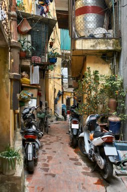 Sarı evler ve park edilmiş motosikletler ile pitoresk Asya şehir sokak