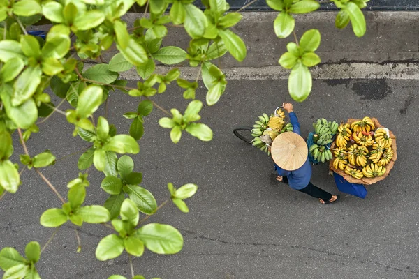 Persoon in Aziatische bamboe hoed wandelen met bananen op fiets buitenshuis — Stockfoto
