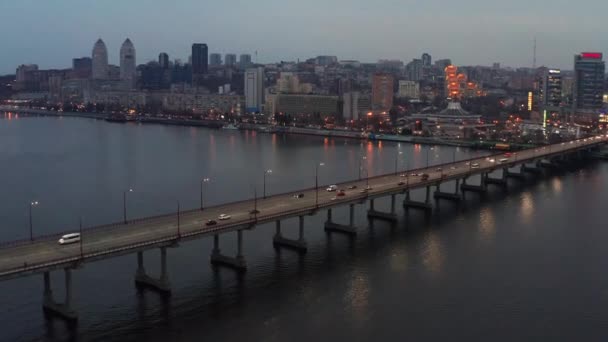 Avond stadsgezicht met brug met verkeer door de rivier — Stockvideo