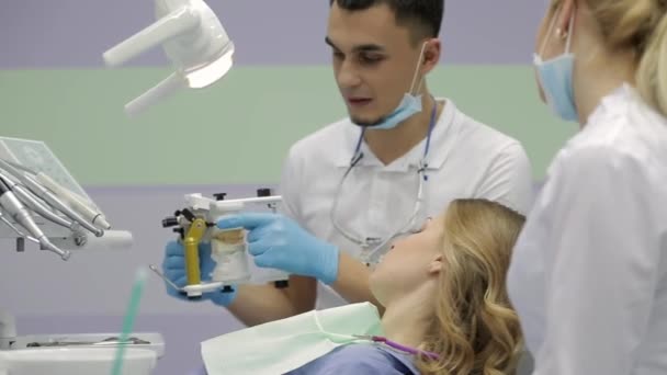 Mooie vrouw een bezoek aan haar tandarts in kliniek — Stockvideo