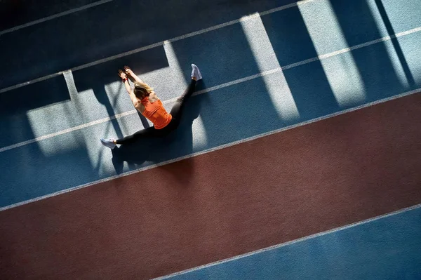 Mulher loira esportiva treinando no estádio indoor — Fotografia de Stock