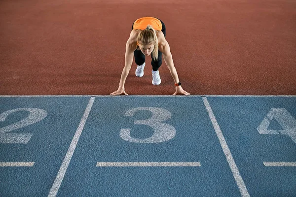 Femme blonde athlétique s'entraînant au stade intérieur — Photo