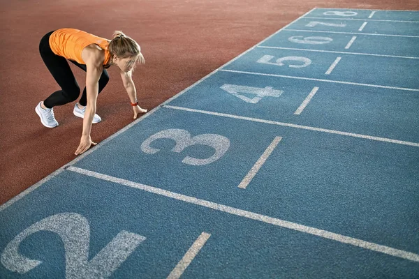 Mulher loira atlética treinando no estádio indoor — Fotografia de Stock