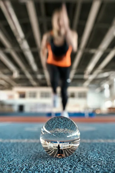 Reflexión de la mujer deportiva en bola de vidrio durante su entrenamiento — Foto de Stock